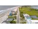 Aerial view of a coastal neighborhood near a sandy beach and lush marshlands at 1568 E Ashley Ave, Folly Beach, SC 29439