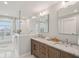 Bathroom featuring double sink vanity, marble countertops, glass enclosed shower with marble surround, and water views at 1568 E Ashley Ave, Folly Beach, SC 29439