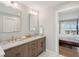 Bathroom featuring double sink vanity with wood cabinets, marble countertops, and decorative seashell accent at 1568 E Ashley Ave, Folly Beach, SC 29439