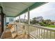 Relaxing porch area with wooden deck, white railings, and peaceful neighborhood views at 1568 E Ashley Ave, Folly Beach, SC 29439