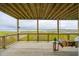 Inviting covered porch with wood flooring, railing, porch swing, side table and beautiful water views at 1568 E Ashley Ave, Folly Beach, SC 29439