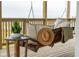 Inviting porch swing with pillows and hat, a peaceful outdoor living space with a snake plant on a side table at 1568 E Ashley Ave, Folly Beach, SC 29439