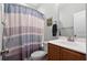 Bathroom with striped shower curtain, toilet, and wood-style vanity with sink at 1578 Stanwick Dr, Johns Island, SC 29455