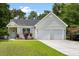 Charming one-story home with light green siding, well-manicured lawn, and an attached two-car garage at 1578 Stanwick Dr, Johns Island, SC 29455