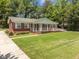 Beautiful exterior view of a red brick home with a long front porch and lush, green lawn at 1593 Teague St, Charleston, SC 29407