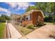 Charming brick home featuring a spacious front porch, manicured landscaping, and a convenient ramp for accessibility at 1593 Teague St, Charleston, SC 29407
