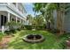 Green backyard featuring manicured lawn, garden with beautiful hedges, and a timeless stone fountain at 16 Trumbo St, Charleston, SC 29401