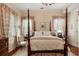 Bedroom with four poster bed, wood flooring, and patterned window treatments at 16 Trumbo St, Charleston, SC 29401