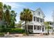 Charming two-story home with white siding, black shutters, and lush palm trees, showcasing classic elegance at 16 Trumbo St, Charleston, SC 29401