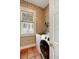 Well-lit laundry room with a modern washer, wallpaper, and a view to the exterior at 16 Trumbo St, Charleston, SC 29401