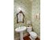 Stylish powder room features a pedestal sink, patterned wallpaper, and an ornate mirror at 16 Trumbo St, Charleston, SC 29401