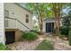 Charming brick pathway leads to a backyard cottage, framed by beautiful trees and lush landscaping at 16 Trumbo St, Charleston, SC 29401