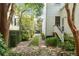 Picturesque brick walkway flanked by lush gardens, leading to a tranquil side entrance at 16 Trumbo St, Charleston, SC 29401