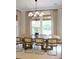 Dining room with a wooden table and seating under a chandelier, illuminated by natural light through large windows at 1723 Bolden Dr, Mount Pleasant, SC 29466
