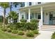 Inviting front porch featuring white columns, blue shutters, a light blue front door, and meticulously maintained landscaping at 1723 Bolden Dr, Mount Pleasant, SC 29466