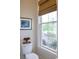 Cozy powder room featuring a window with a bamboo shade, and an adjacent toilet at 1723 Bolden Dr, Mount Pleasant, SC 29466