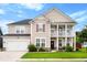 Charming two-story home with a manicured lawn, a two-car garage, and a cozy front porch at 175 Basket Grass Ln, Summerville, SC 29486