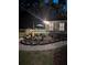 Inviting backyard with a deck, elegant landscaping, and a brick path leading to the house at night at 189 Fox Chase Dr, Goose Creek, SC 29445