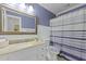 A calming bathroom featuring a granite vanity, shiplap paneling, and a blue-striped shower curtain at 189 Fox Chase Dr, Goose Creek, SC 29445