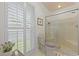 Bright bathroom with toilet and shower, featuring shuttered windows which allows for natural light to fill the room at 189 Fox Chase Dr, Goose Creek, SC 29445