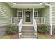 Inviting front porch with a white railing, a decorative wreath, and potted plants at 189 Fox Chase Dr, Goose Creek, SC 29445