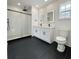 Modern bathroom featuring a glass enclosed shower, double vanity, illuminated mirrors and black tiled floor at 1906 Gumwood Blvd, North Charleston, SC 29406
