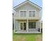 Back exterior of a two-story home with a balcony, covered patio, and well-maintained lawn at 1906 Gumwood Blvd, North Charleston, SC 29406