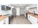 Well-lit kitchen features white cabinets, stainless appliances, wood counters, and light-colored hardwood floors at 20 Stratton Dr, Charleston, SC 29420