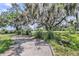 Gravel driveway with lush landscaping and large trees at 200 Wappoo Rd, Charleston, SC 29407