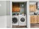 Convenient laundry room with washer, dryer and wooden cabinets for storage at 200 Wappoo Rd, Charleston, SC 29407