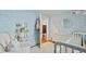 Bedroom with blue floral wallpaper, white dresser, round mirror, and open doorway to hallway at 2060 Wappoo Hall Rd, Charleston, SC 29412