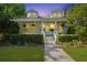 Charming two-story home featuring a well-manicured lawn and inviting front porch with elegant columns and dormer windows at 2060 Wappoo Hall Rd, Charleston, SC 29412
