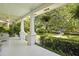 Inviting front porch with white columns, fern hangings, and a view of the lush landscaping at 2060 Wappoo Hall Rd, Charleston, SC 29412
