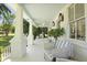 Spacious front porch with wicker seating, vintage lighting and views of the landscaped front yard at 2060 Wappoo Hall Rd, Charleston, SC 29412