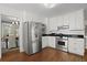 Well-lit kitchen featuring stainless steel appliances, white cabinets, and black countertops at 2060 Wappoo Hall Rd, Charleston, SC 29412