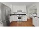 Bright kitchen featuring modern stainless steel appliances, white cabinetry, and hardwood floors at 2060 Wappoo Hall Rd, Charleston, SC 29412