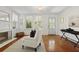 Cozy living room with hardwood floors, a fireplace, and a white armchair near bright windows at 2060 Wappoo Hall Rd, Charleston, SC 29412