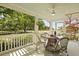 Cozy porch area with ceiling fan, wooden table, chairs, and relaxing hanging chair at 2060 Wappoo Hall Rd, Charleston, SC 29412