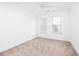 Bright, carpeted bedroom featuring a ceiling fan and natural light from two windows at 21 George St # 206, Charleston, SC 29401