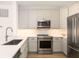 Updated kitchen showcasing stainless steel appliances, granite countertops, and stylish cabinetry at 21 George St # 206, Charleston, SC 29401