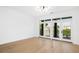 Bright living room featuring hardwood floors, white walls, and a balcony with scenic views at 21 George St # 206, Charleston, SC 29401