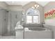 This luxurious bathroom features a large tub, walk-in shower, and arched window with lots of natural light at 2105 Loblolly Ln, Seabrook Island, SC 29455