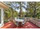 Beautiful deck area with a dining table set overlooking serene water views surrounded by mature trees at 2105 Loblolly Ln, Seabrook Island, SC 29455