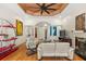 Bright living room featuring hardwood floors, white sofas, a modern ceiling fan and artistic decor at 2105 Loblolly Ln, Seabrook Island, SC 29455
