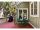 Charming outdoor patio area with a green table and chairs, accessible from a glass door entrance and featuring a grill at 2105 Loblolly Ln, Seabrook Island, SC 29455