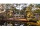 Picturesque waterfront home framed by mature trees, reflecting in the calm pond water at 2105 Loblolly Ln, Seabrook Island, SC 29455