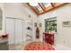 Bright sunroom featuring a skylight, large windows with plants, and an adjacent kitchen with a view at 2105 Loblolly Ln, Seabrook Island, SC 29455