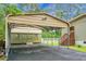 Carport featuring driveway, storage shed, stairs to house, and well-maintained lawn at 222 Sinclair Rd, Summerville, SC 29483