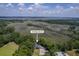 An aerial view of the home nestled among mature trees with views of the marsh and a nearby bridge at 2340 Ashley River Rd, Charleston, SC 29414