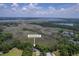 See this aerial view of the home nestled among mature trees with beautiful views of the marsh at 2340 Ashley River Rd, Charleston, SC 29414